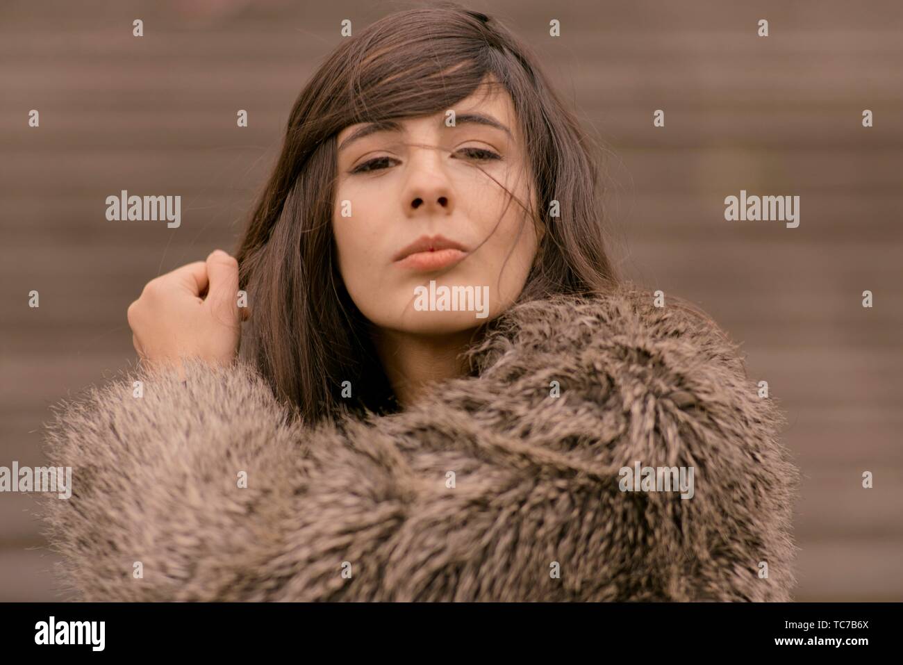 portrait of playful woman curling lips and playing with styled hairs