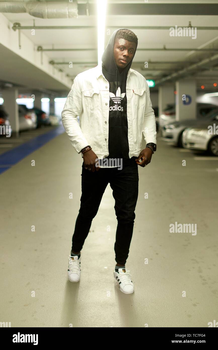 street style male blogger wearing Adidas sweater clothes in parking garage,  in Munich, Germany Stock Photo - Alamy