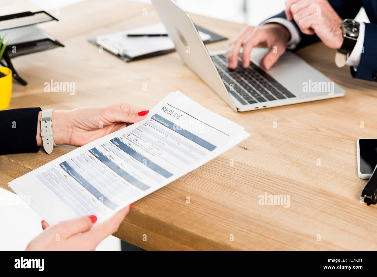 cropped view of recruiter using - Cropped View Of Recruiter Using Laptop Near Woman Holding Resume TC7K01 