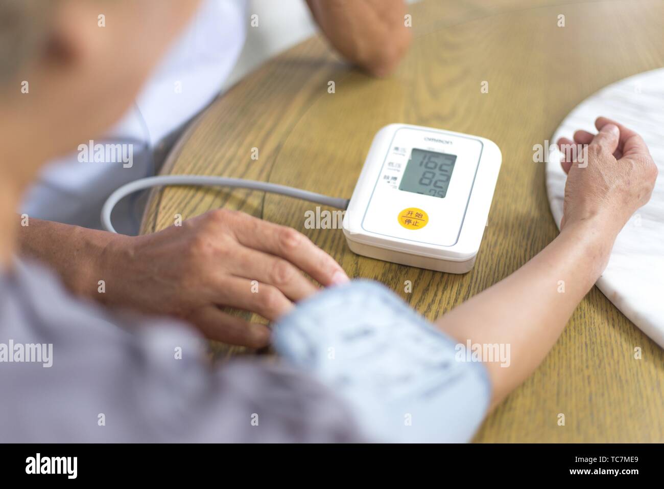 Elderly woman measuring her blood pressure with electronic blood