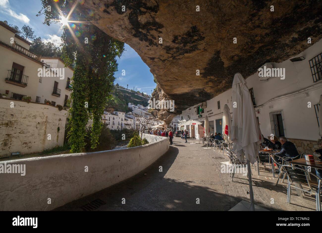 Setenil, Spain - March 4th, 2019: Street with dwellings built into rock  overhangs. Setenil de las Bodegas, Cadiz, Spain. Restaurants under rock  Stock Photo - Alamy