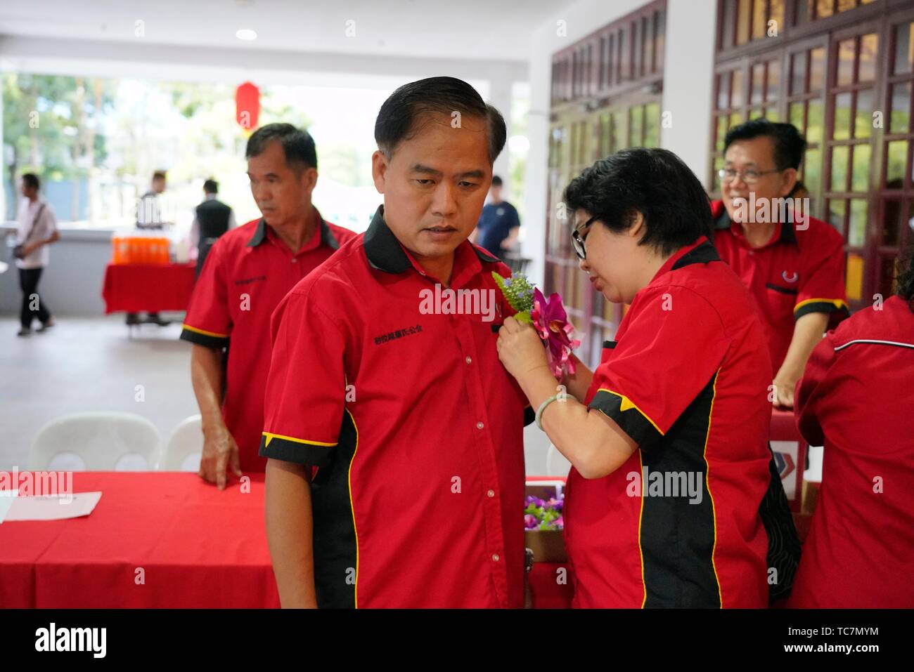 Pinning flower for VIP during Sarawak Chai's Clan Association Chinese New Year dinner party in Kuching, Malaysia. Stock Photo