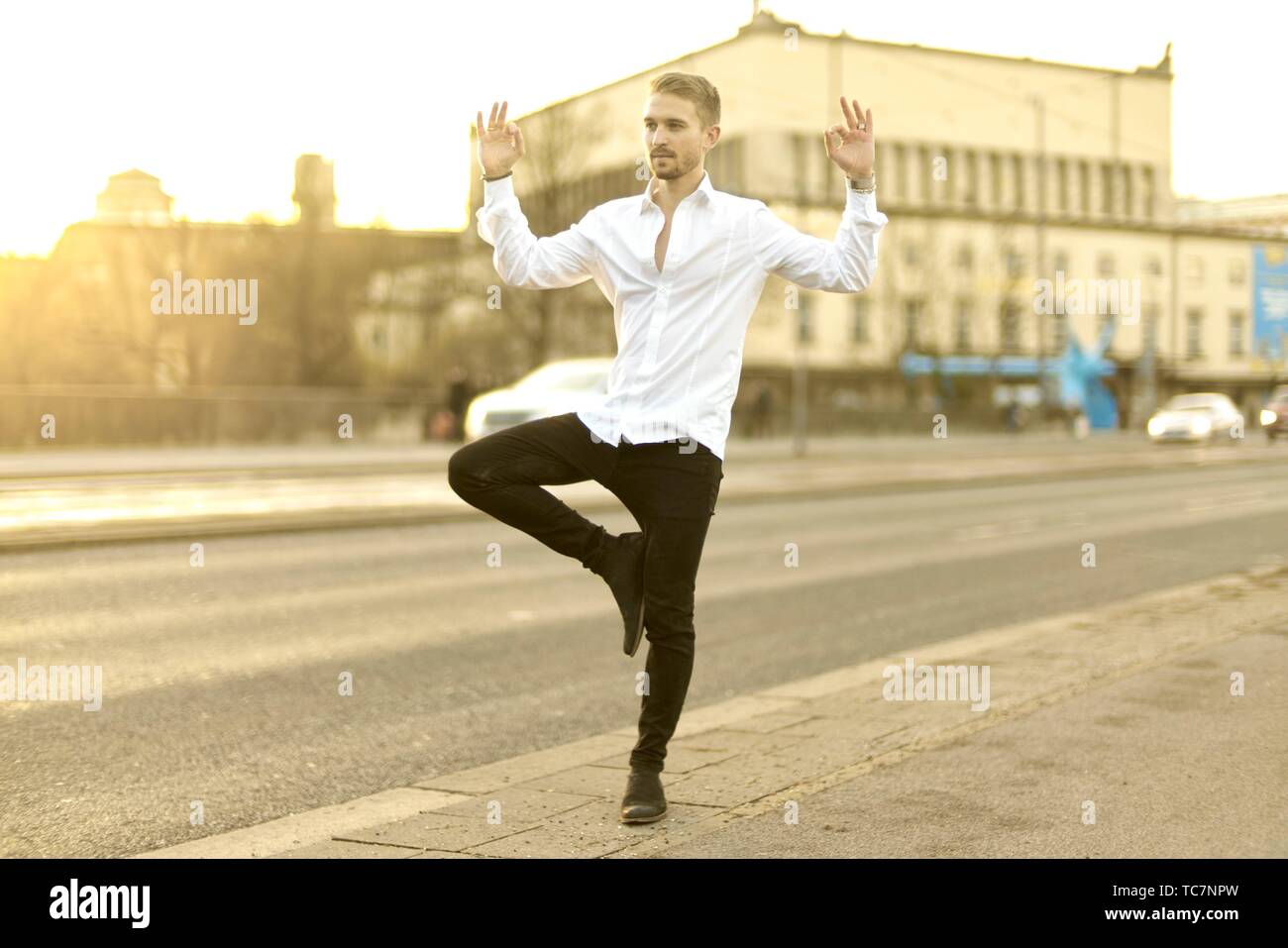 calm relaxed young man balancing on one foot at street, meditating, in  Munich, Germany Stock Photo - Alamy