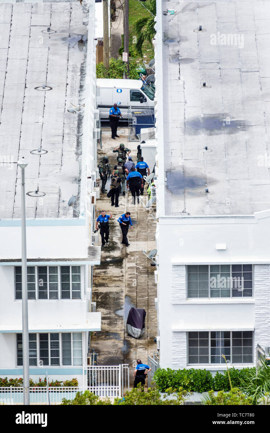 Miami Beach Florida,North Beach,police policeman policemen SWAT team arrest arrested,Black man men male,criminal,alley between residential buildings,F Stock Photo