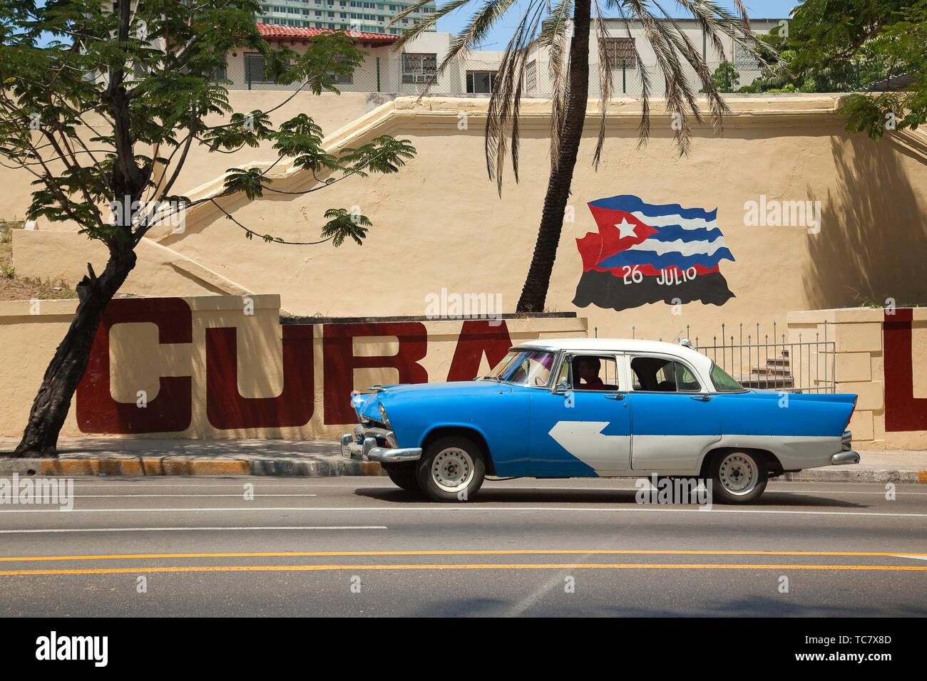 Old American car at the street in front of the wall paintings at Vedado district, Havana, La Habana, Cuba, West Indies, Central America Stock Photo