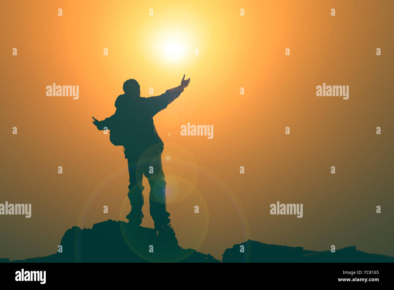 Man with arms extended toward heaven at sunrise ,pay respect prayer concept for faith spirituality Stock Photo