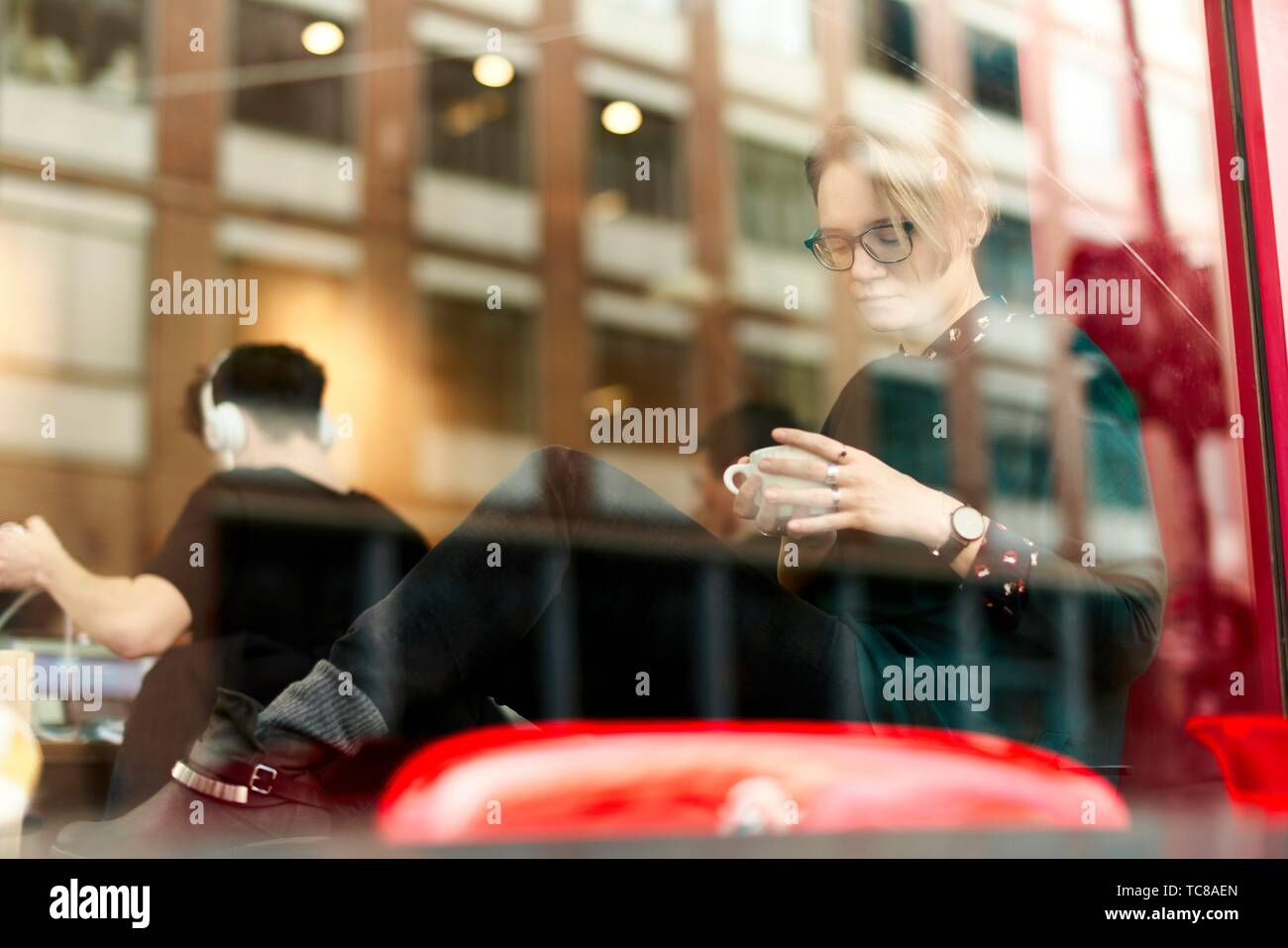 woman-behind-glass-window-indoors-in-coffee-shop-in-munich-germany