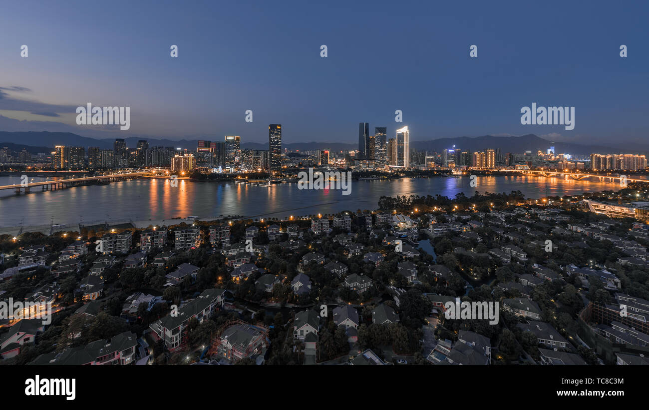 On both sides of the Minjiang River, the most high-end residential and office buildings in Fuzhou on both sides of the Minjiang River, urban night view of the CBD villa area in the north of the Minjiang River. Stock Photo