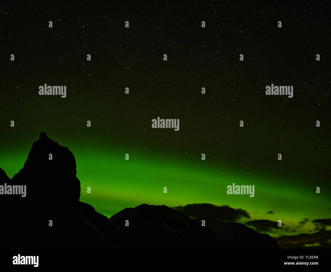 Starry sky and the Aurora Borealis behind a mountain range in Iceland Stock Photo