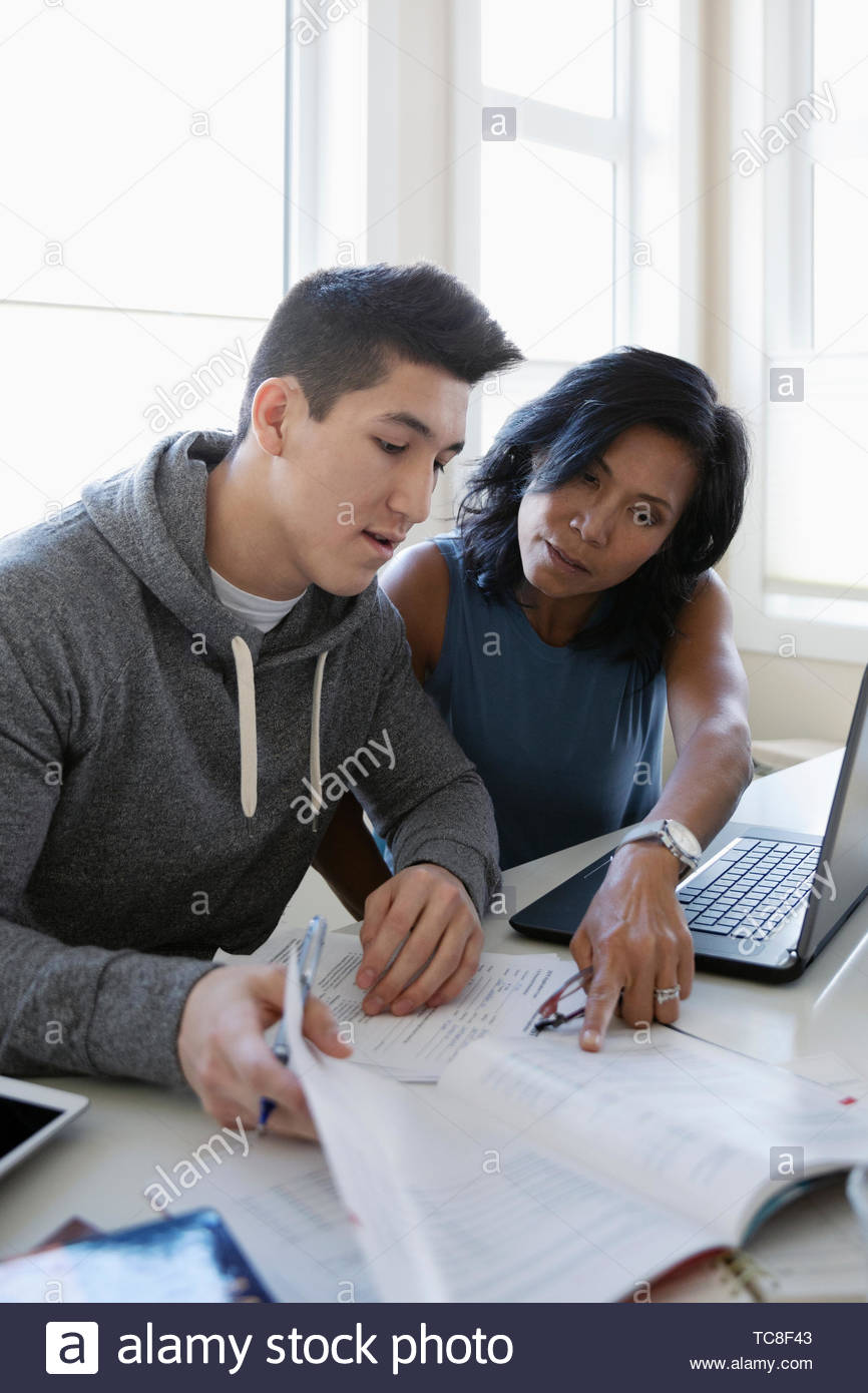 Mother helping teenage son fill out college application Stock Photo
