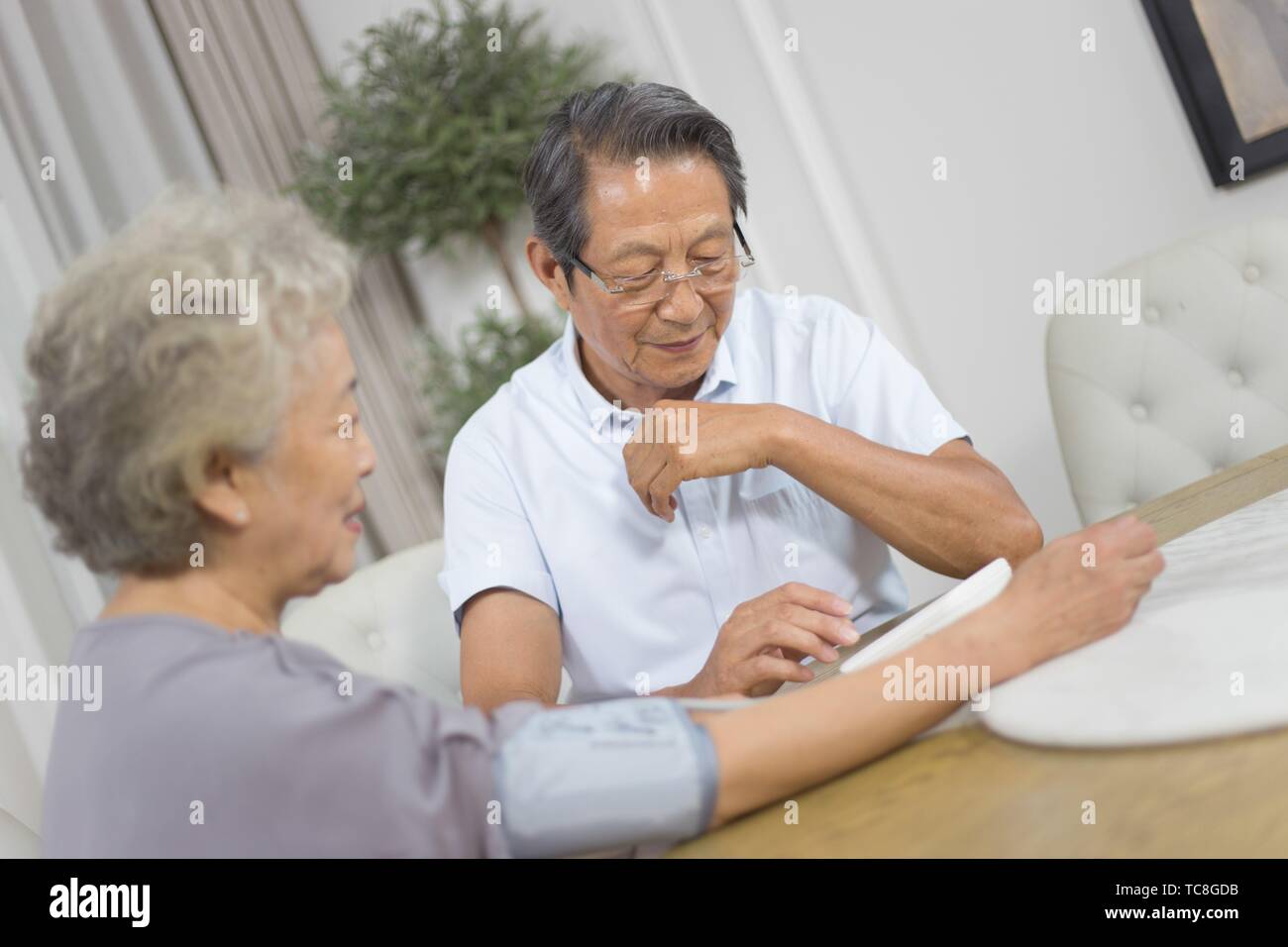 Elderly woman measuring her blood pressure with electronic blood