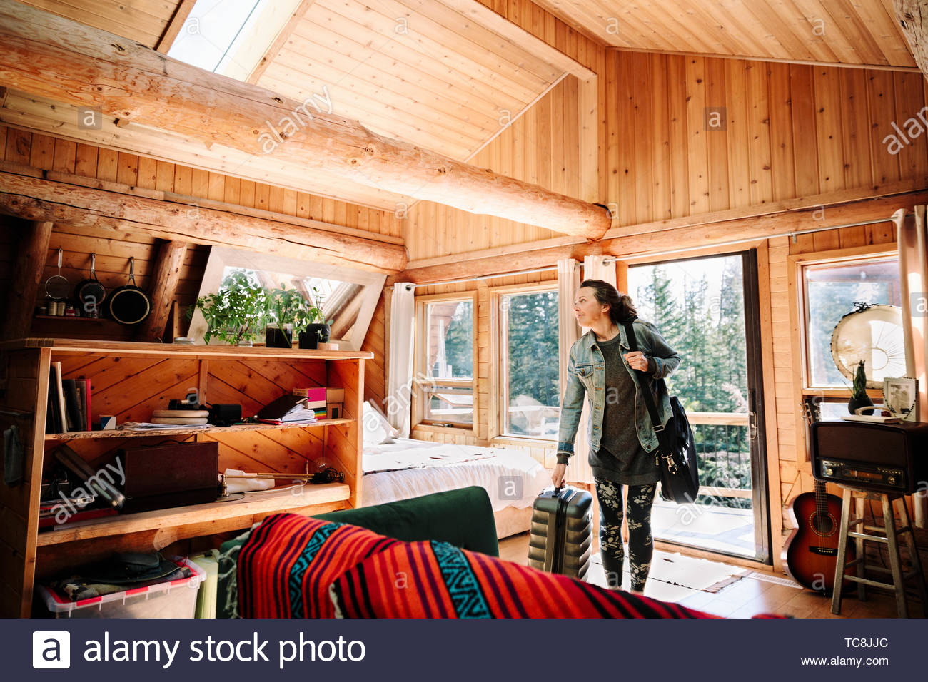 Woman with suitcase arriving at cabin Stock Photo