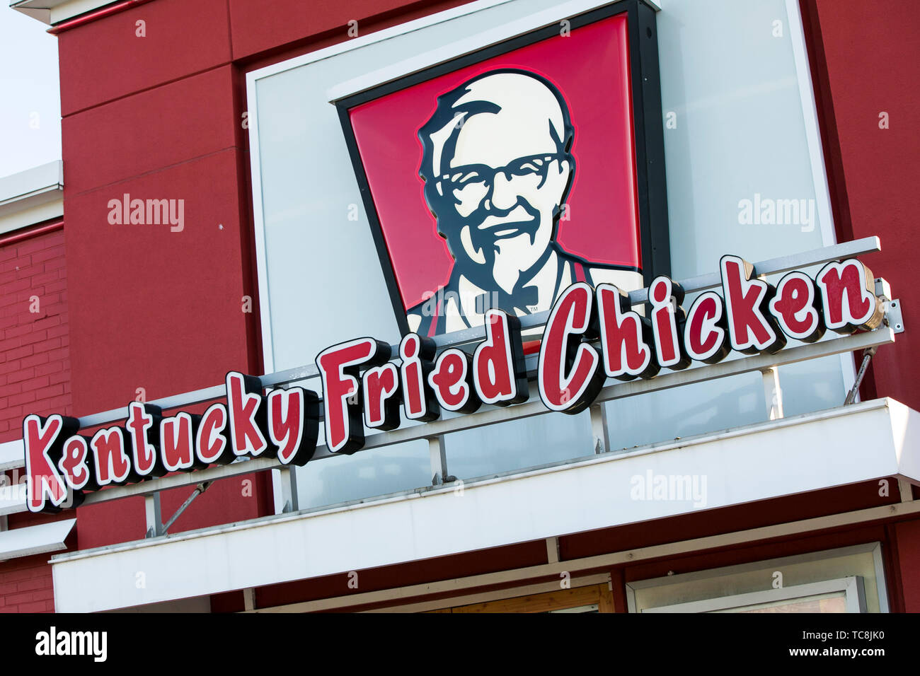 A logo sign outside of a Kentucky Fried Chicken (KFC) fast food