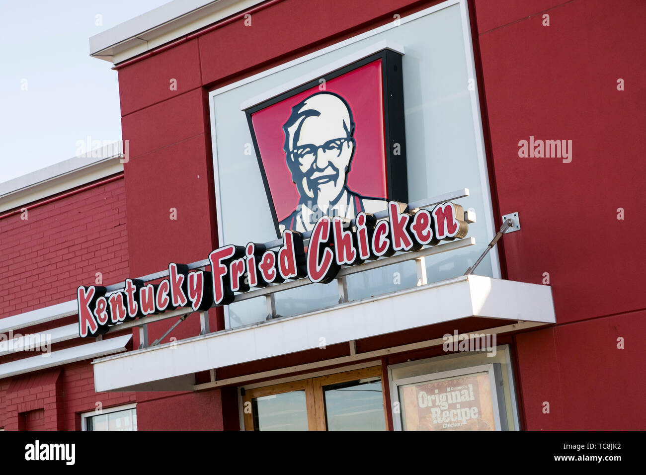 A logo sign outside of a Kentucky Fried Chicken (KFC) fast food