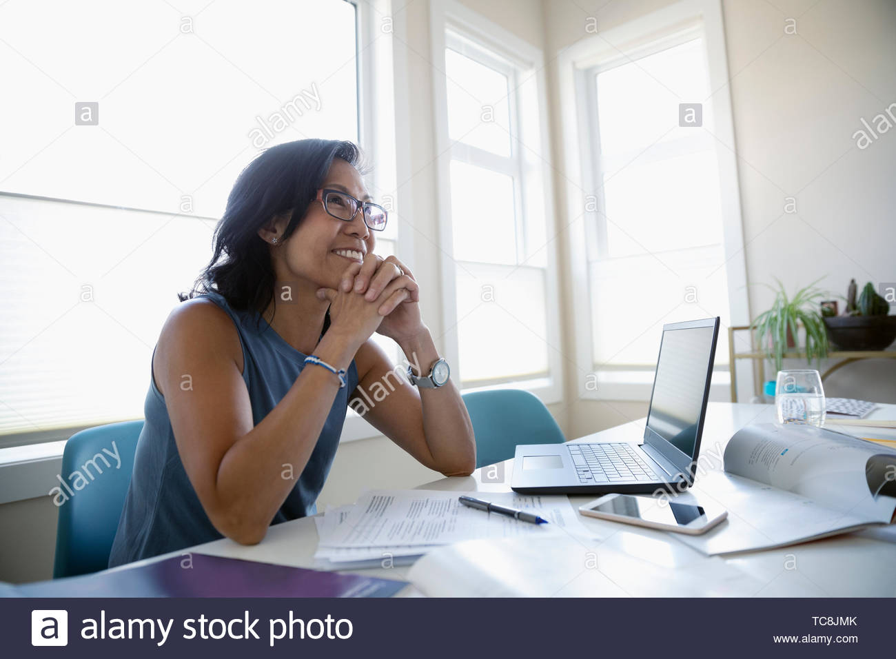 Smiling mature student studying at laptop Stock Photo