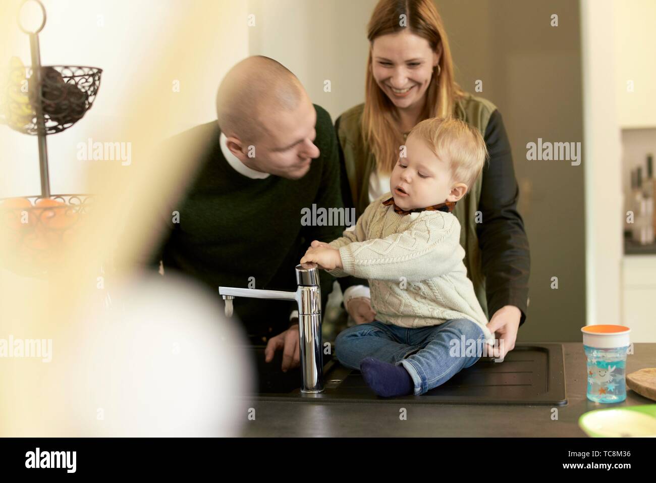 parents with baby toddler child next to water faucet in kitchen at home, in  Cottbus, Brandenburg, Germany Stock Photo - Alamy