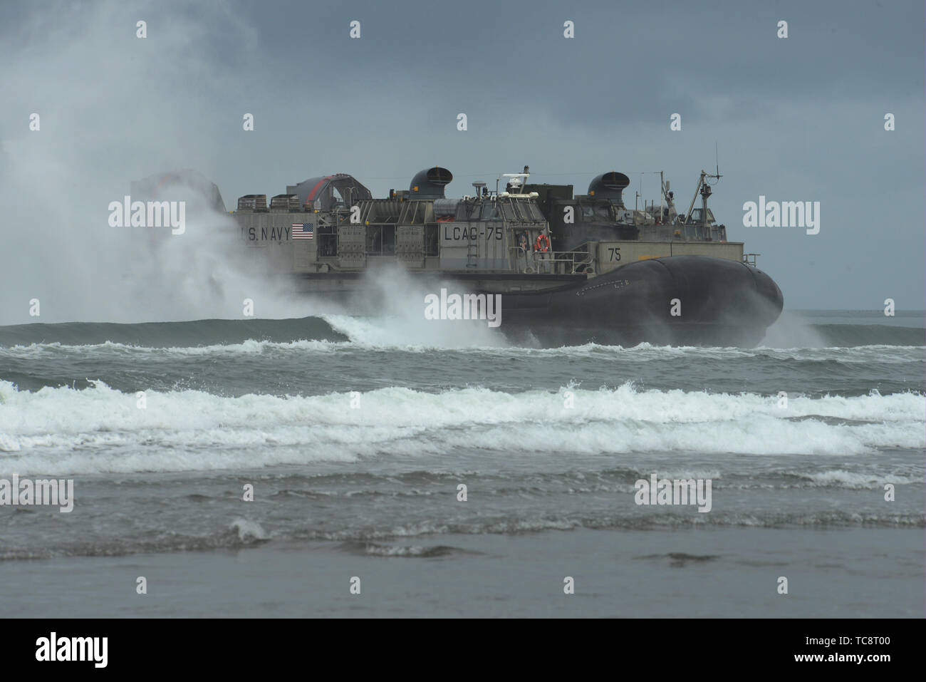 A U.S. Navy (Landing Craft Air Cushion) LCAC-75 comes ashore at the Sunset Beach are near Warrenton, Oregon, June 3, 2019. In addition to the beach landings by the hovercraft vehicles, community leaders, emergency managers, military officials and other first responders toured the U.S.S. Anchorage to learn more about the Navy capabilities to assist in mass casualty scenarios. (National Guard photo by John Hughel, Oregon Military Department) Stock Photo