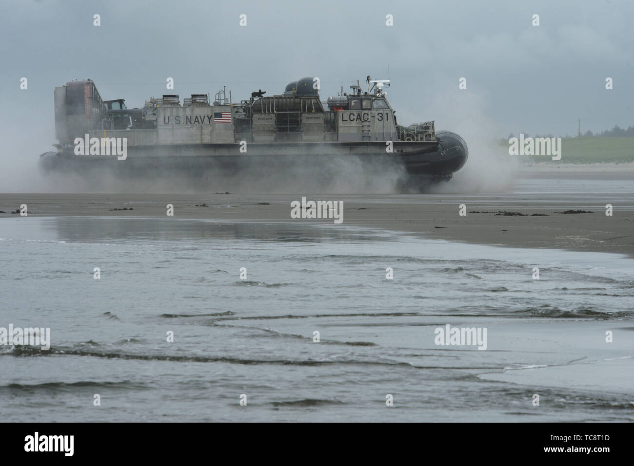 A U.S. Navy (Landing Craft Air Cushion) LCAC-31 comes ashore at the Sunset Beach are near Warrenton, Oregon, June 3, 2019. In addition to the beach landings by the hovercraft vehicles, community leaders, emergency managers, military officials and other first responders toured the U.S.S. Anchorage to learn more about the Navy capabilities to assist in mass casualty scenarios. (National Guard photo by John Hughel, Oregon Military Department) Stock Photo