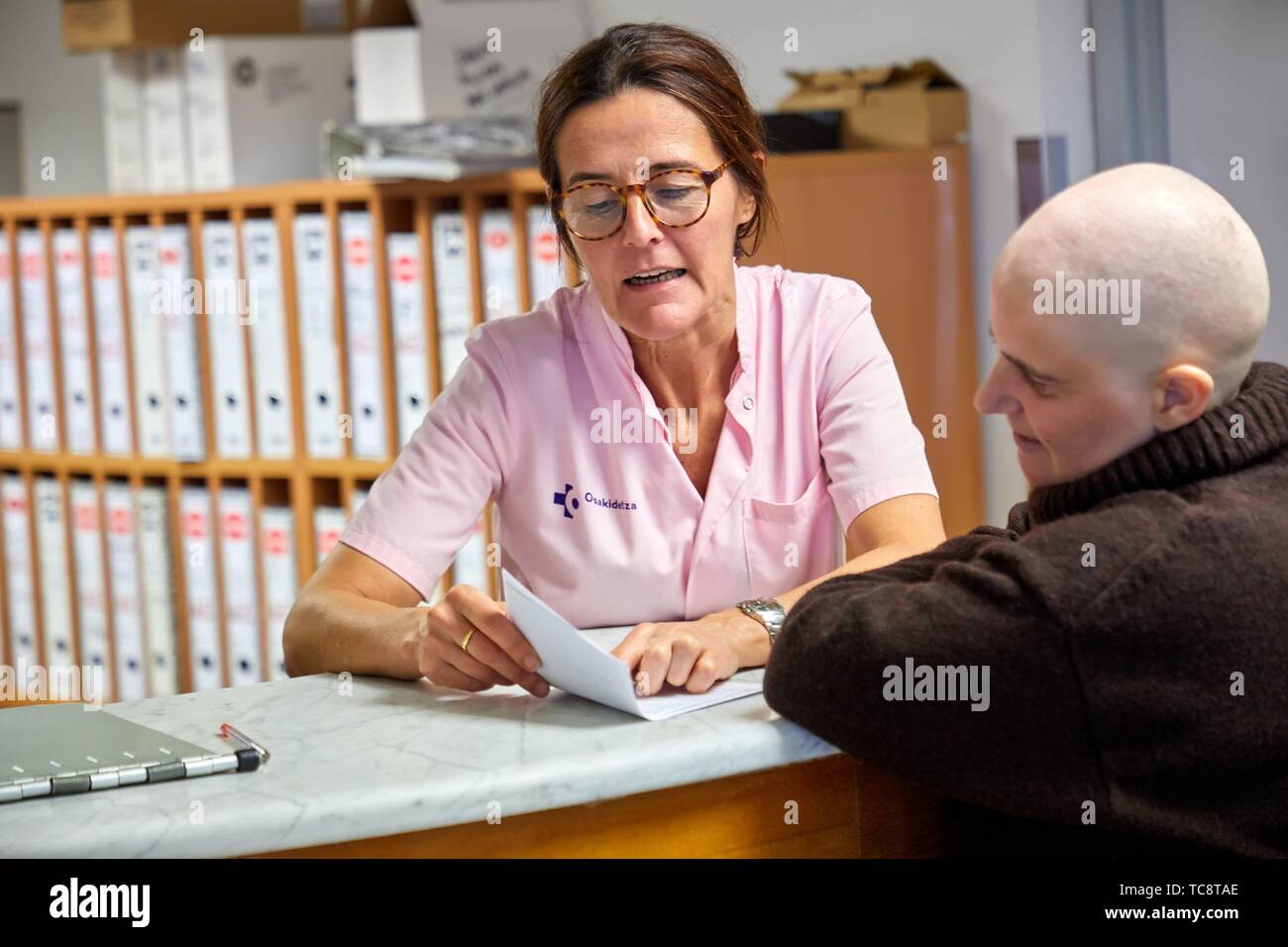 Nursing assistant attends cancer patient in hospital reception, Oncology, Hospital Donostia, San Sebastian, Gipuzkoa, Basque Country, Spain Stock Photo