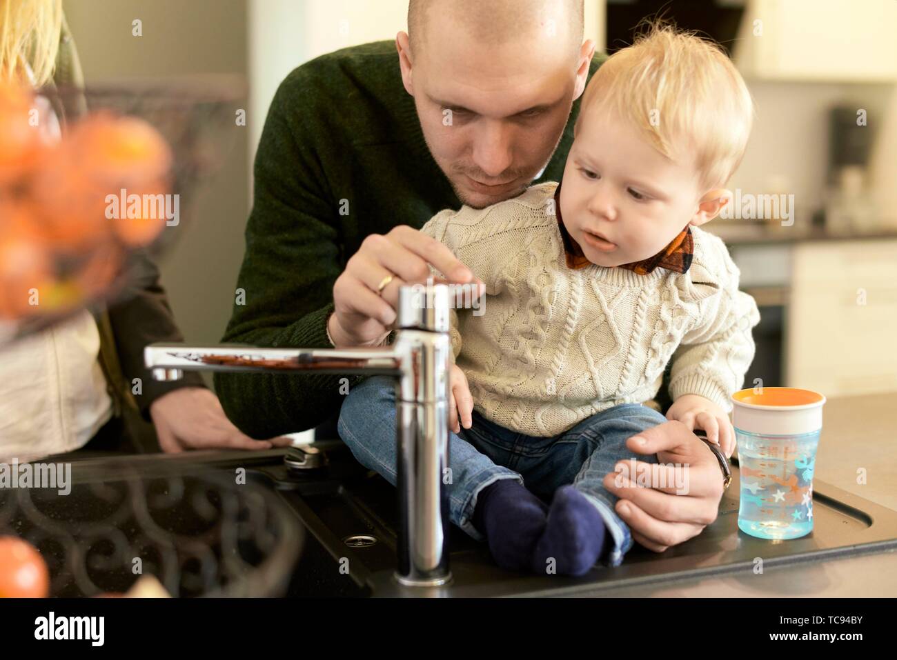 father with baby toddler child next to water faucet in kitchen at home, in  Cottbus, Brandenburg, Germany Stock Photo - Alamy