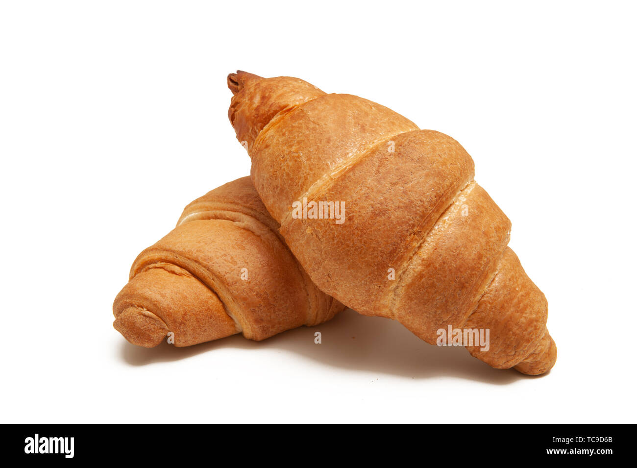 two baked croissants on a white background. Stock Photo
