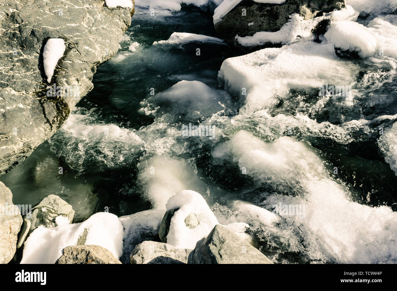 Mountain river in winter. Cold water flows among rocks. Journey onriver ...