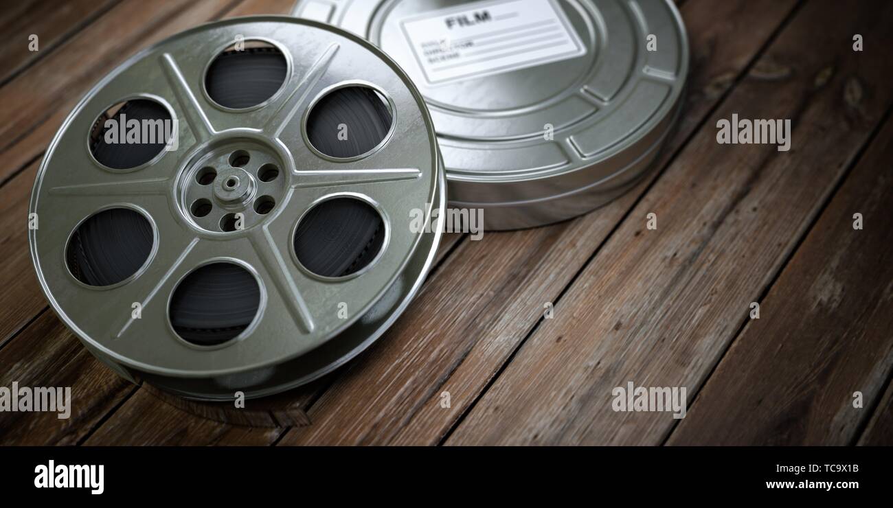 Vintage film reel with filmstrip on wood background. Video, cinema