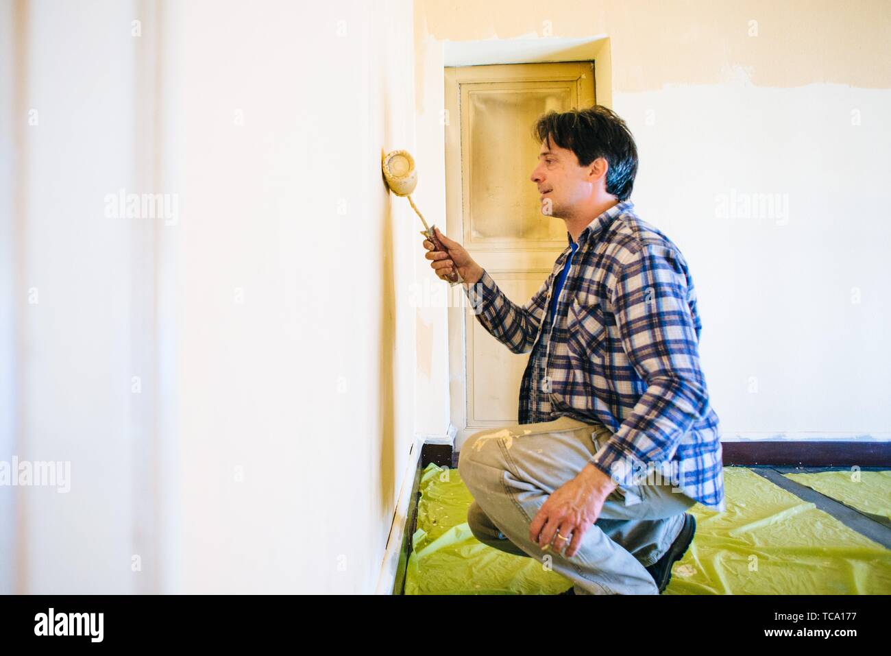 husband father of forty years, paints house wall man painting wall of
