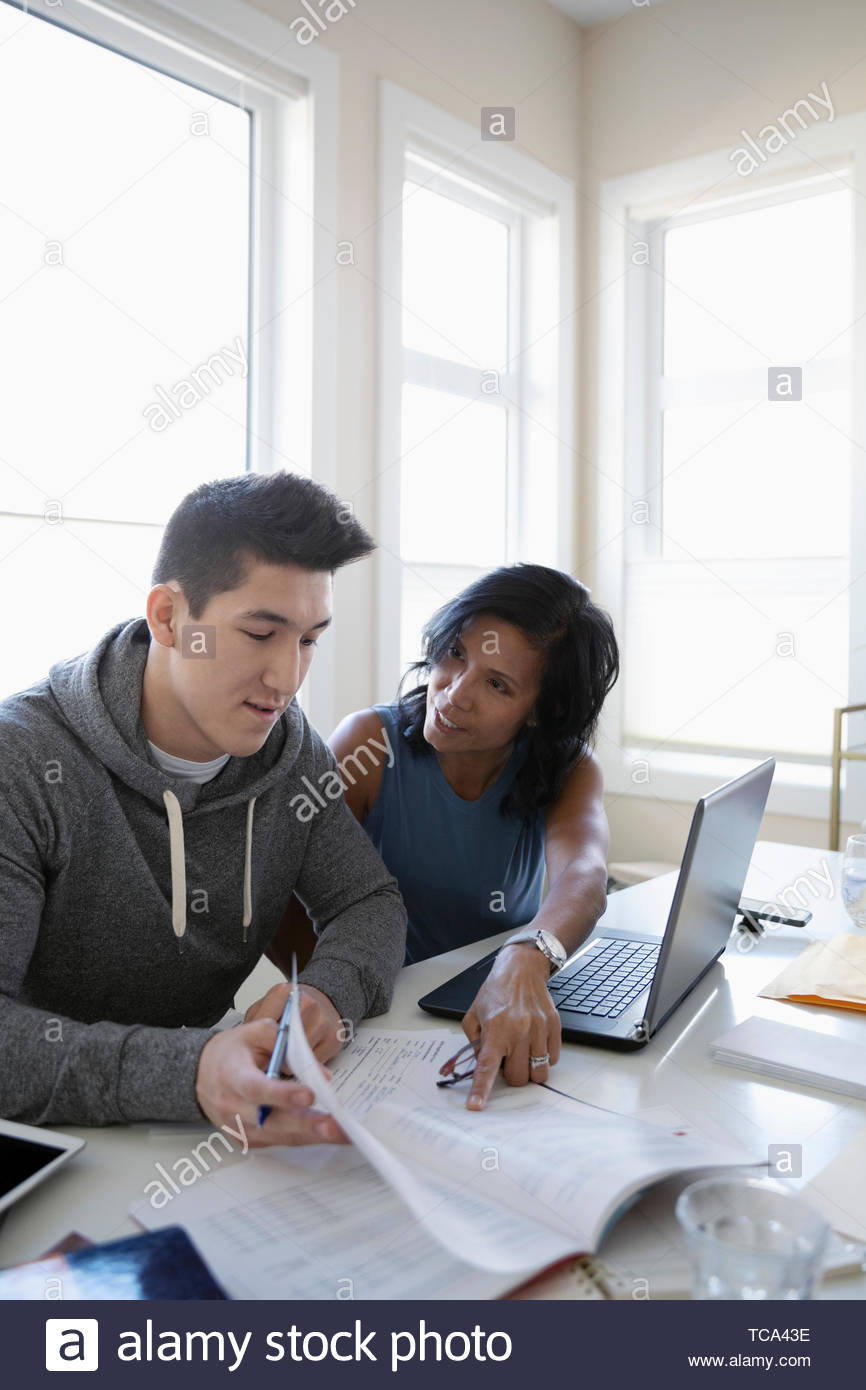 Mother helping son fill out college applications Stock Photo