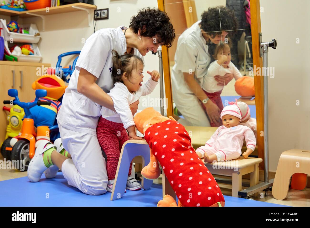 Physiotherapist teaching a girl with Down syndrome to stand up,Rehabilitation, Amara Berri Health Center building, Donostia, San Sebastian, Gipuzkoa, Stock Photo