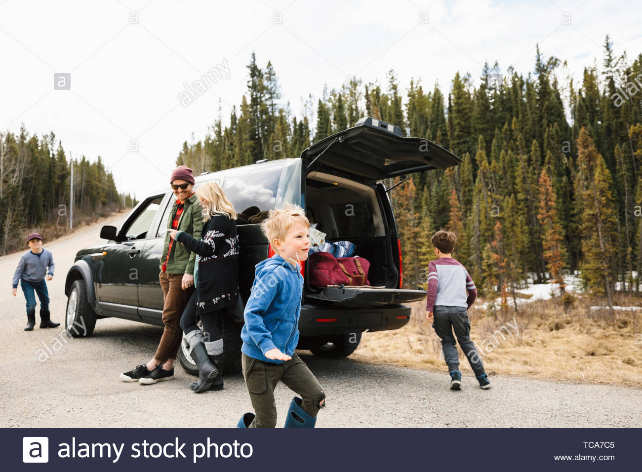 Family standing and playing outside car at remote roadside Stock Photo