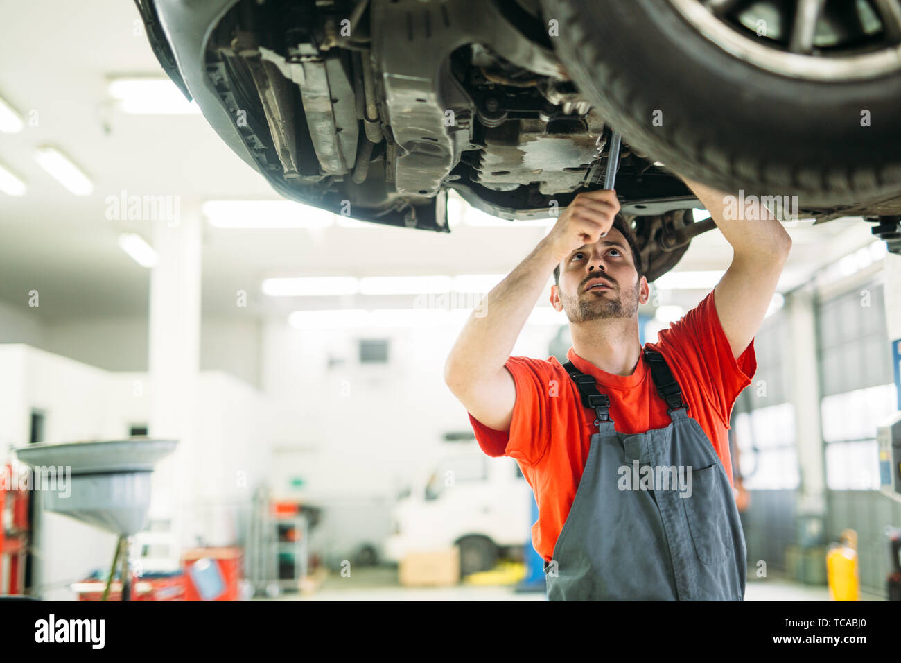 car service, repair, maintenance and people concept - happy smiling auto mechanic man at workshop Stock Photo