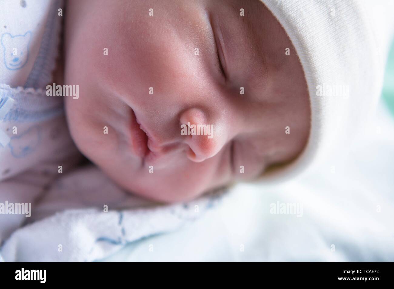 Sleeping few day-old baby newborn. Mellow sleepy newborn phase concept. Stock Photo