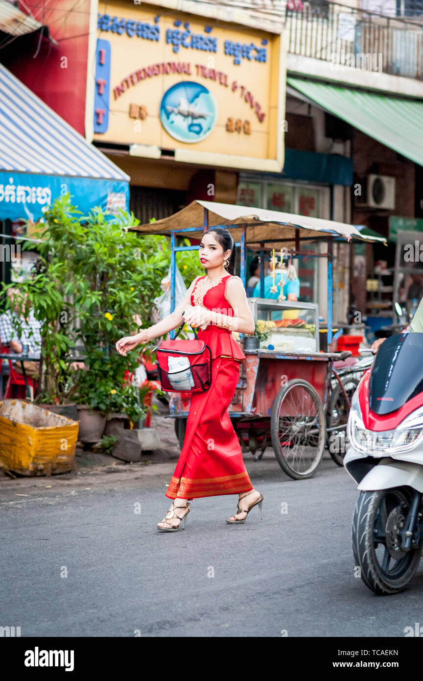 A Beautiful Young Cambodian Girl In A Long Red Dress Makes Her Way To