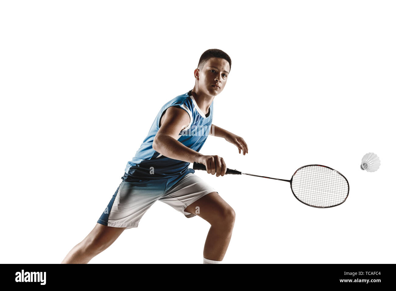 Little boy playing badminton isolated on white studio background. Young  male model in sportwear and sneakers with the racket in action, motion in  game. Concept of sport, movement, healthy lifestyle Stock Photo -