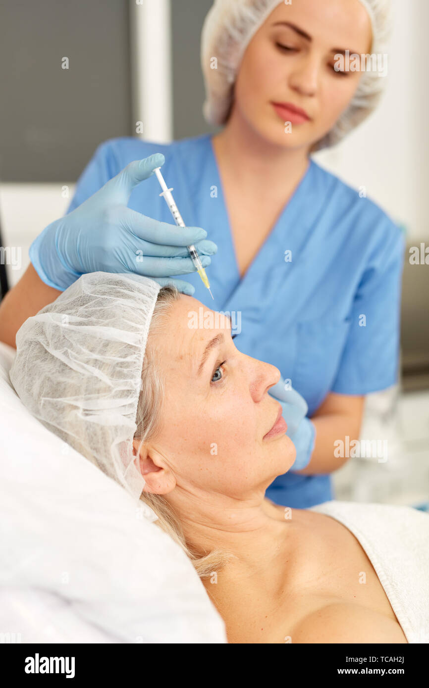Mature woman receiving injections hi-res stock photography and images ...