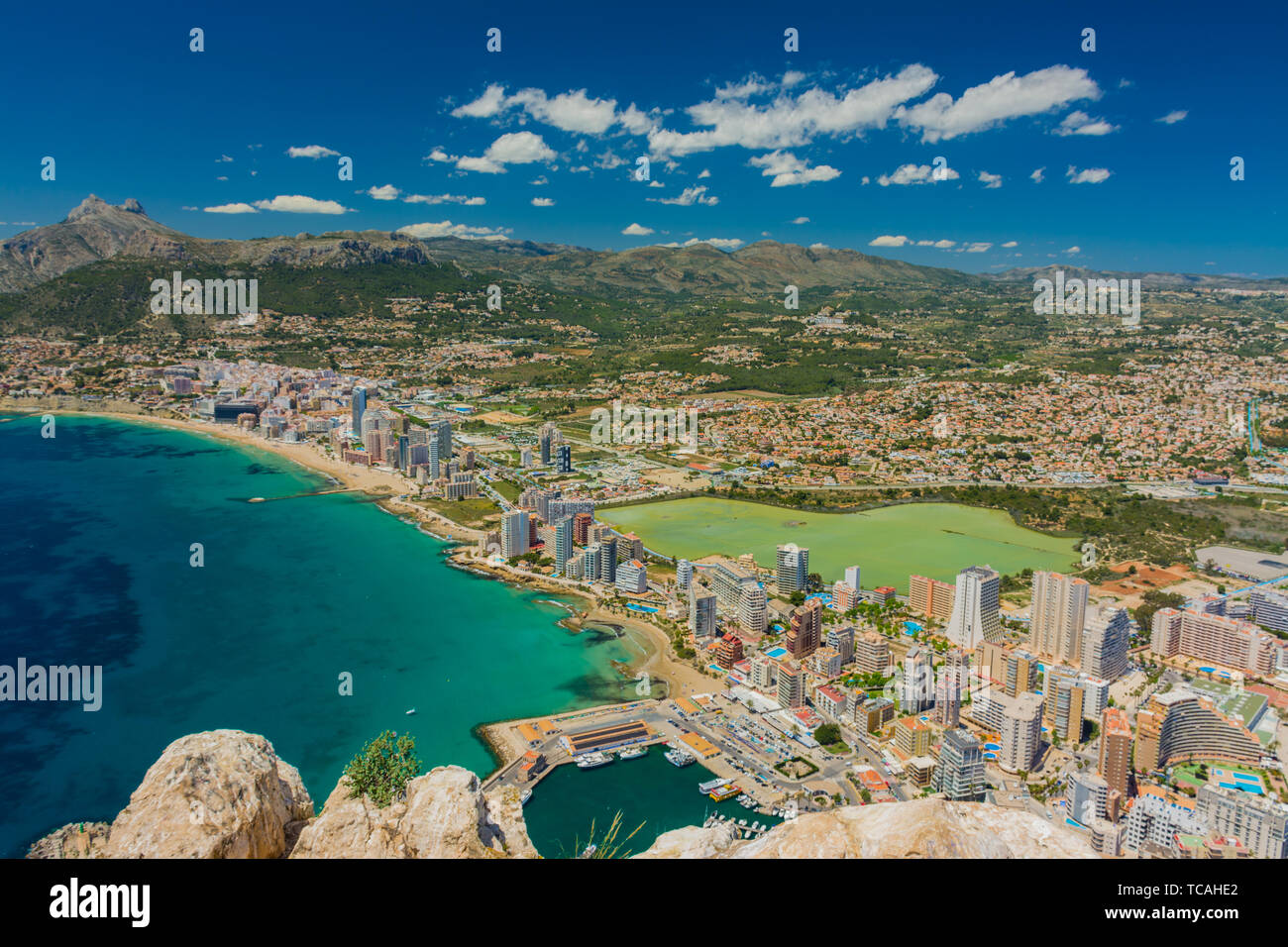 View of the area of apartments and hotels in Calpe, Alicante, Spain, with  the marina and the salt pans. Old town at left side. From the rock of Ifach  Stock Photo -