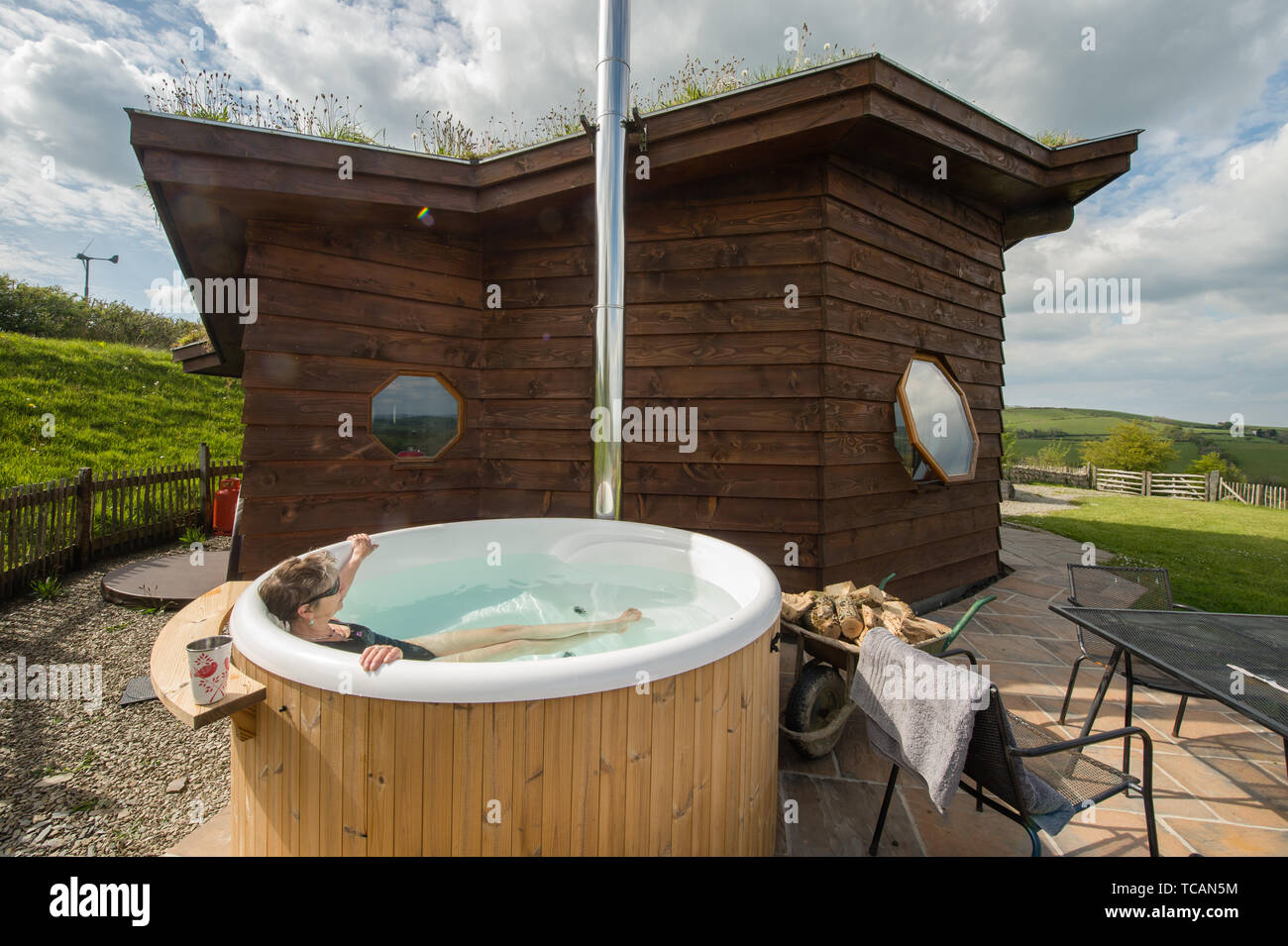 Sustainable tourism in the UK : Treberfedd Farm eco-lodge log cabins with log-burning wood-fuelled outdoor hot tub, Aeron Valley, Ceredigion Wales UK Stock Photo