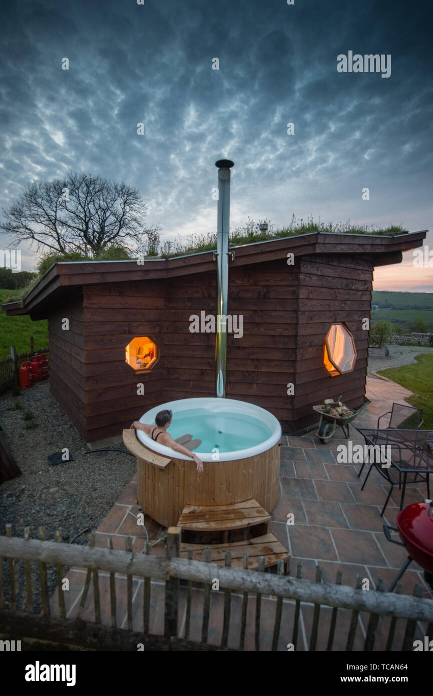 Sustainable tourism in the UK : Treberfedd Farm eco-lodge log cabins with  log-burning wood-fuelled outdoor hot tub, Aeron Valley, Ceredigion Wales UK  Stock Photo - Alamy