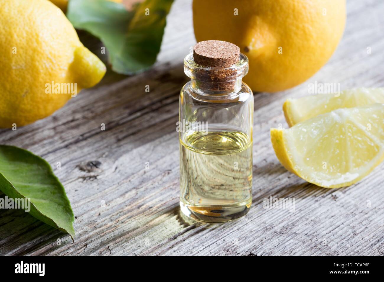 A bottle of essential oil with fresh lemons Stock Photo Alamy