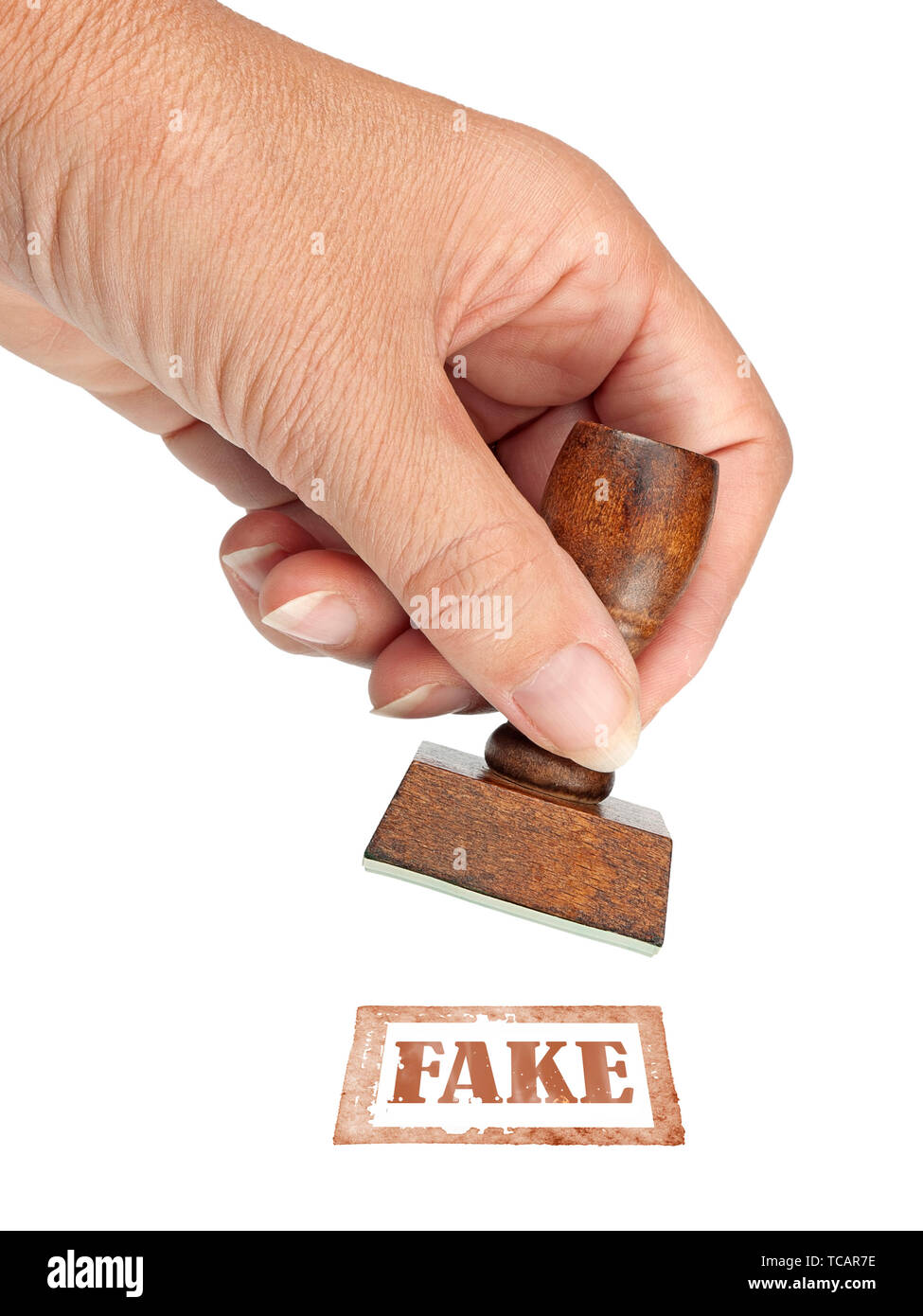 Genuine fake, rubber stamp. My hand with rubber stamp isolated on white. Business, politics or trade ethical concept. Stock Photo