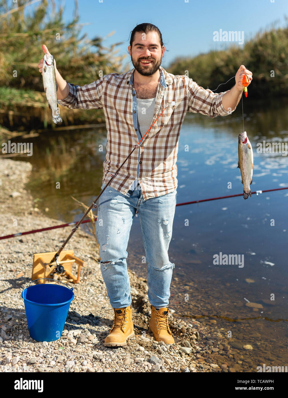 Bearded adult man posing with fish near river in summertime Stock Photo -  Alamy