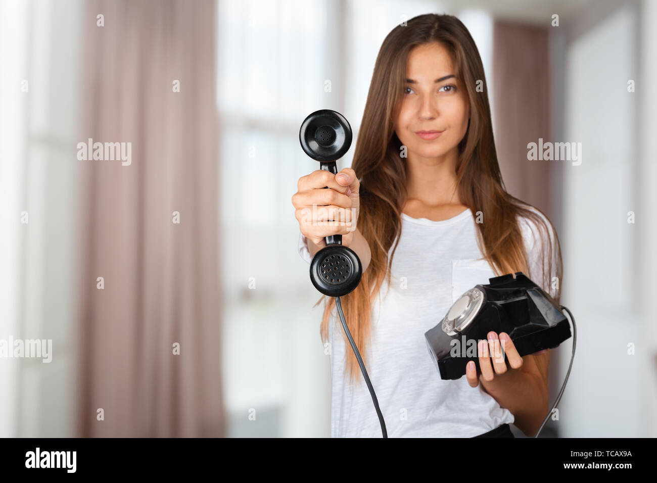 Brunette businesswoman in white shirt holding telephone Stock Photo