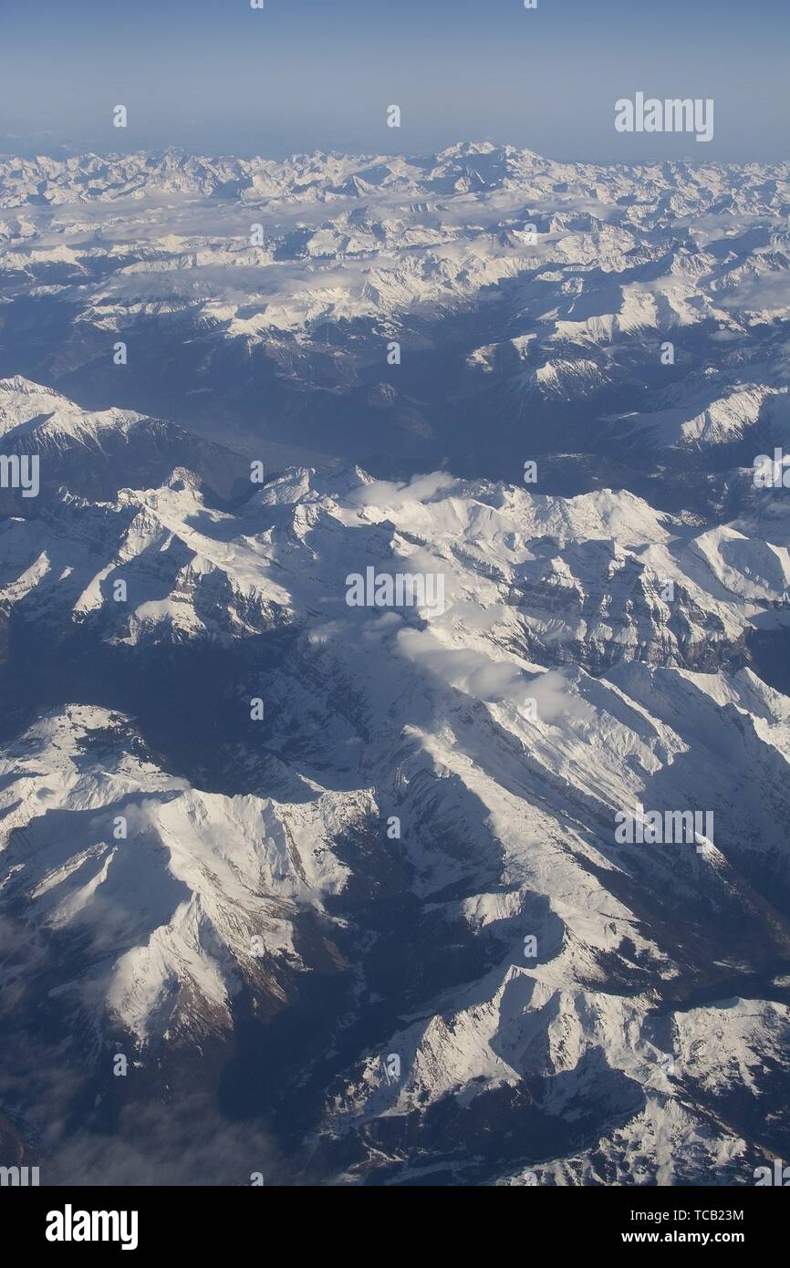 Swiss Alpes with snowy mountain tops aerial view towards the east during afternoon flight in December. Stock Photo