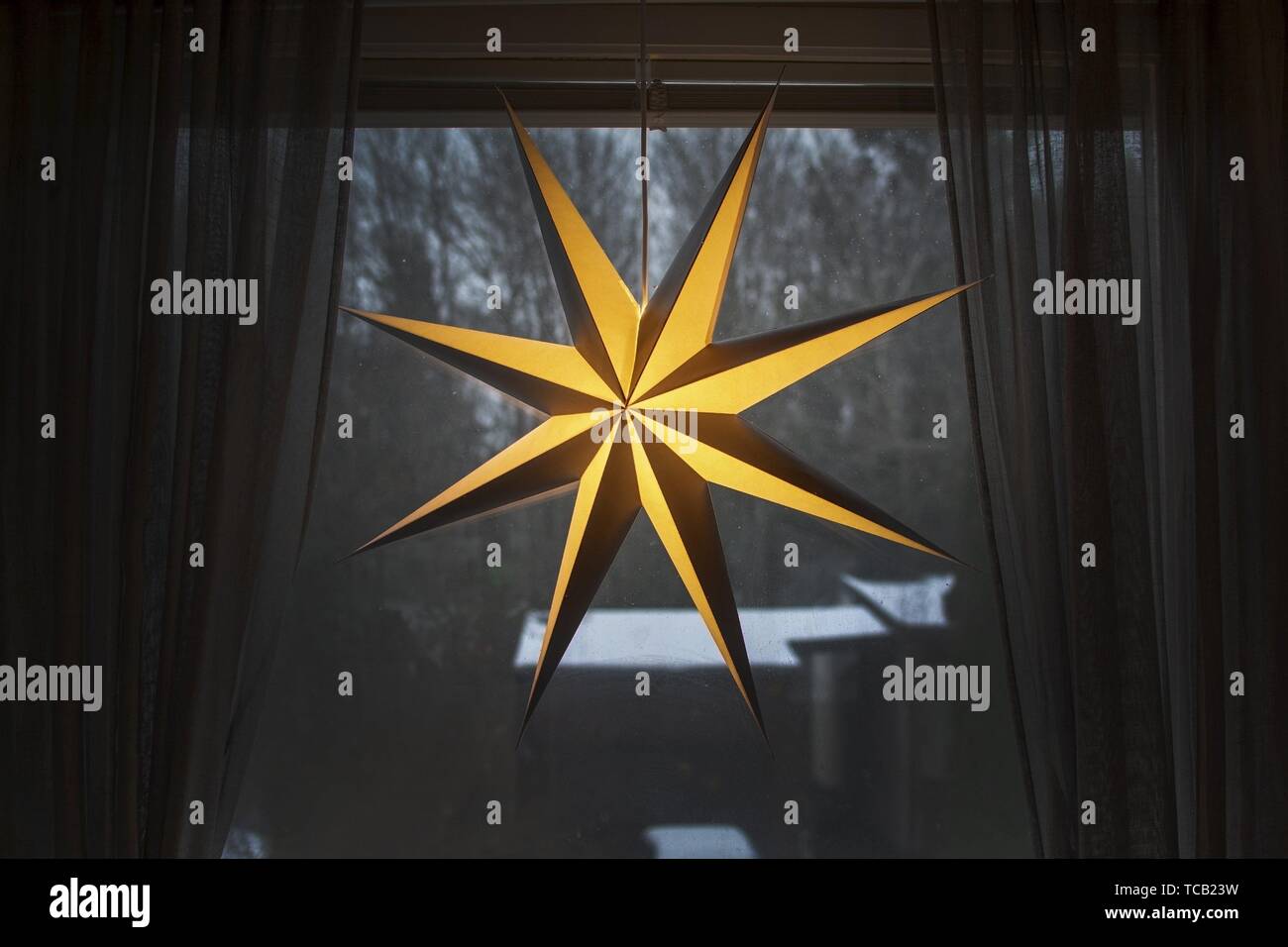 Advent star christmas decorations in window with snow outside in the afternoon in Stockholm, Sweden. Stock Photo