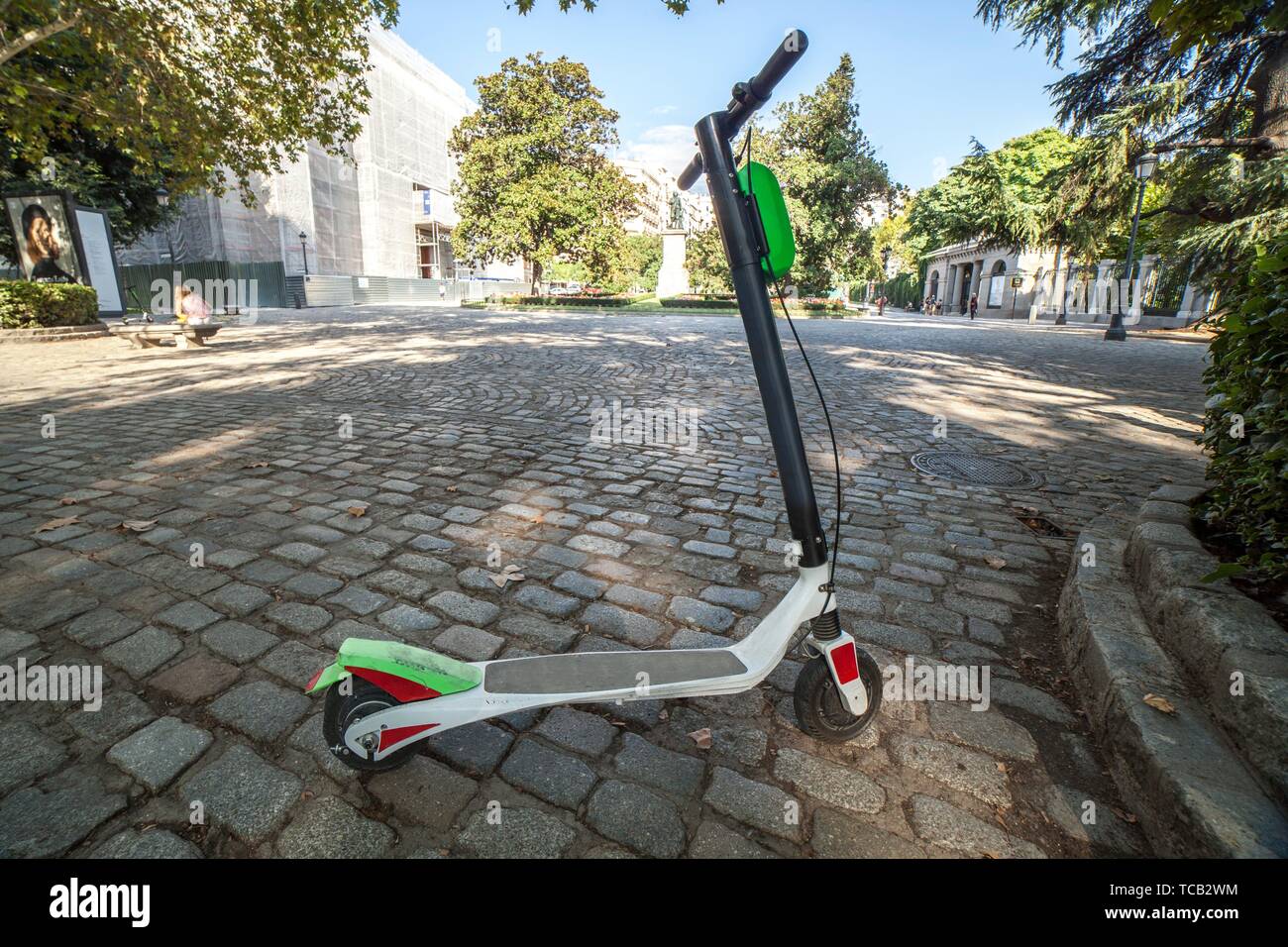 Dockless electric kick scooters from a scooter-sharing system parked on a sidewalk. One vehicule for rent at Madrid old town. Stock Photo