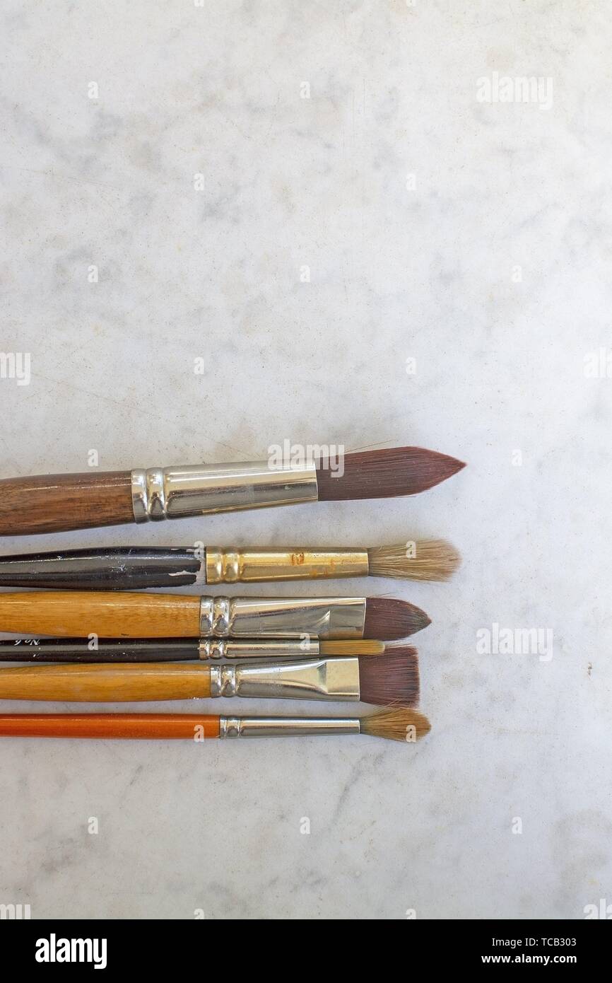 Set of various artist brushes for watercolor painting on old shabby grungy retro vintage wooden background. Stock Photo
