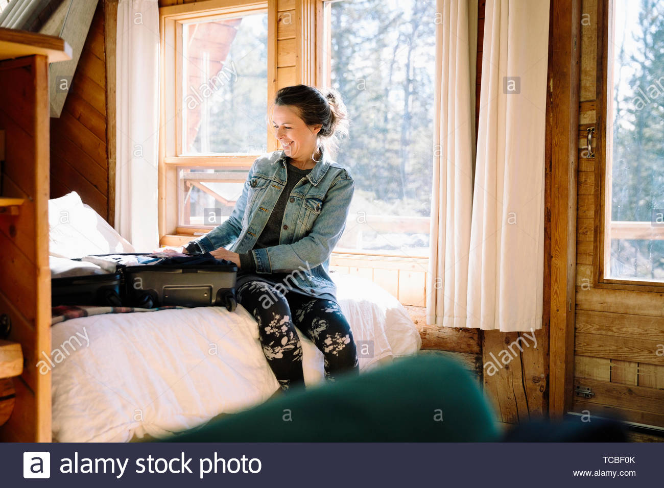 Smiling woman unpacking in cabin Stock Photo