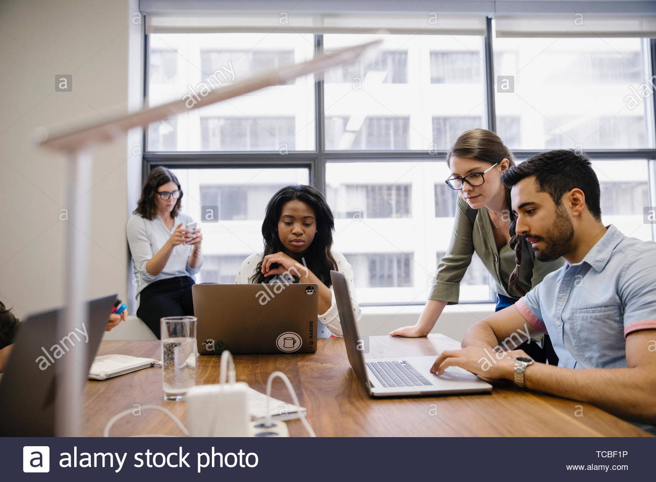 Business people using laptops in conference room meeting Stock Photo ...