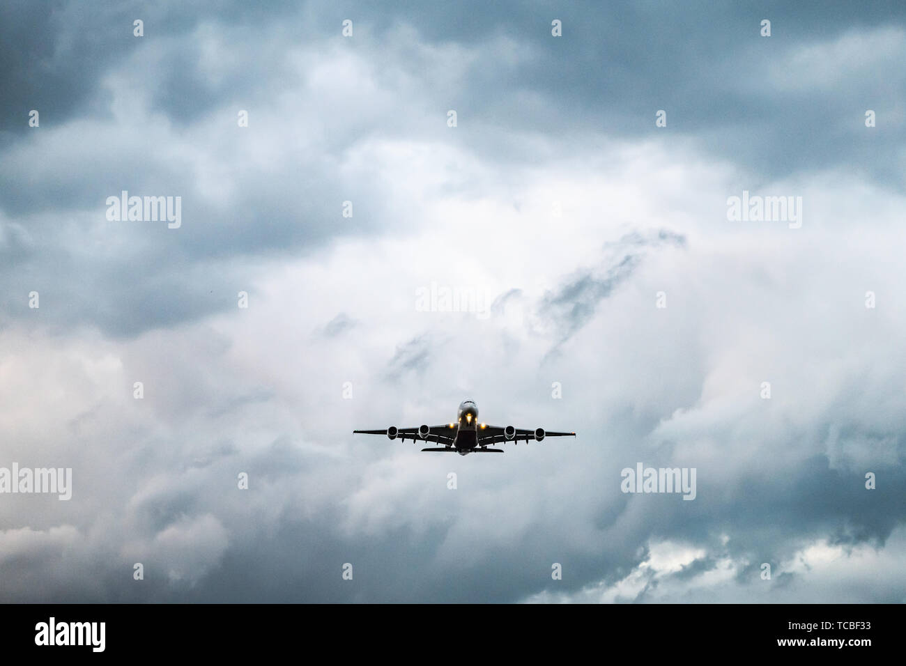 plane takes off from the airport in the night with dark cloudy sky. Stock Photo